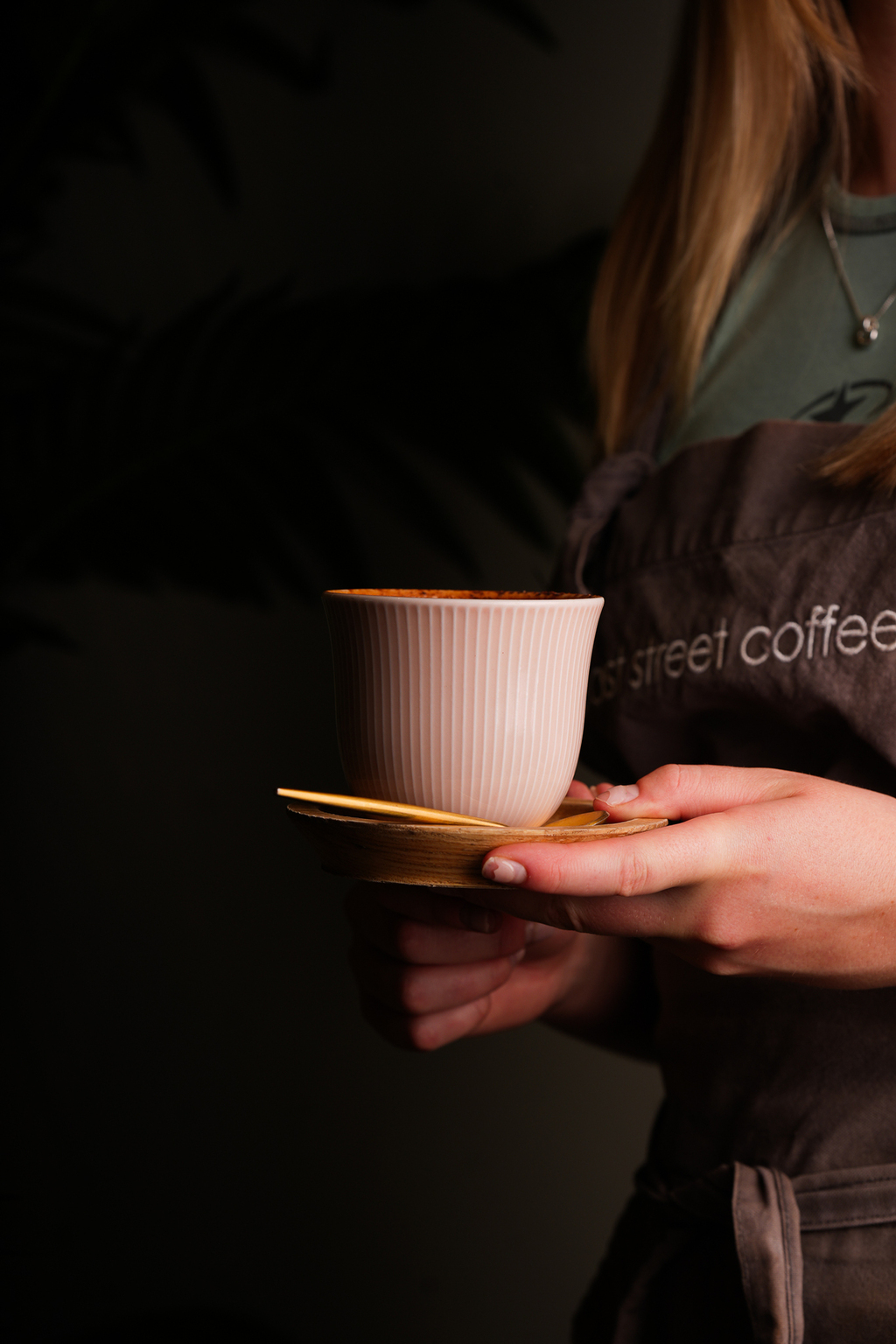 A cup of speciality coffee held by an East Street Coffee barista